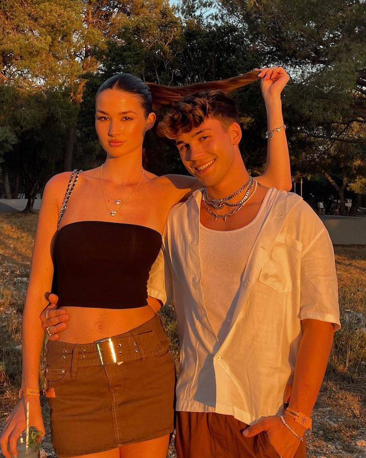 Julien Brown (right) with his right arm around his girlfriend Angelina's waist as she raises her ponytail behind his head.