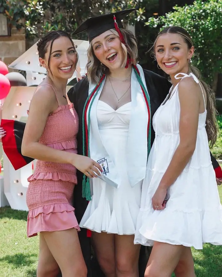Rylan Olivia McKnight (center) in her graduation gown with her twin sisters Bailey McKnight (left) and Brooklyn McKnight (right).