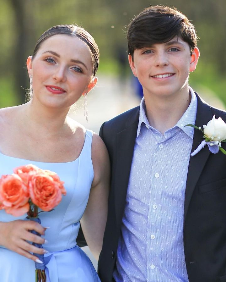 Rylan Olivia McKnight (left) with her prom date on the right while she is holding a yellow mini-bouquet.