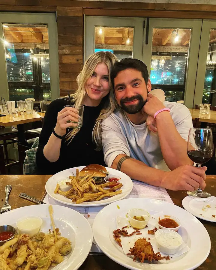 Amanda Kloots and Michael Allio pictured during a dinner while in arms.