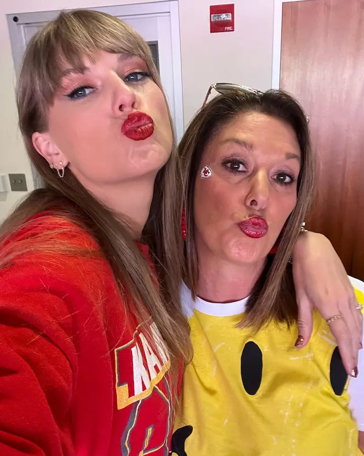 Taylor Swift (left) taking a selfie with Randi Mahomes (right) while both making kissy faces at the camera.